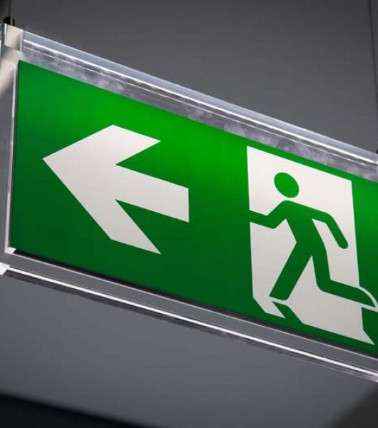 Emergency exit sign above a black doorway