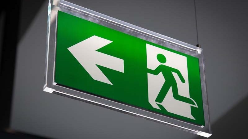 Emergency exit sign above a black doorway